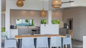 Una cocina moderna con comedor, que cuenta con una gran mesa de madera y sillas azul claro.