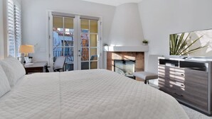 Une chambre à coucher avec un grand lit, un bureau, une chaise, une commode et un téléviseur.