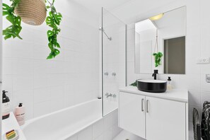 Een haardroger, handdoeken, zeep, toiletpapier