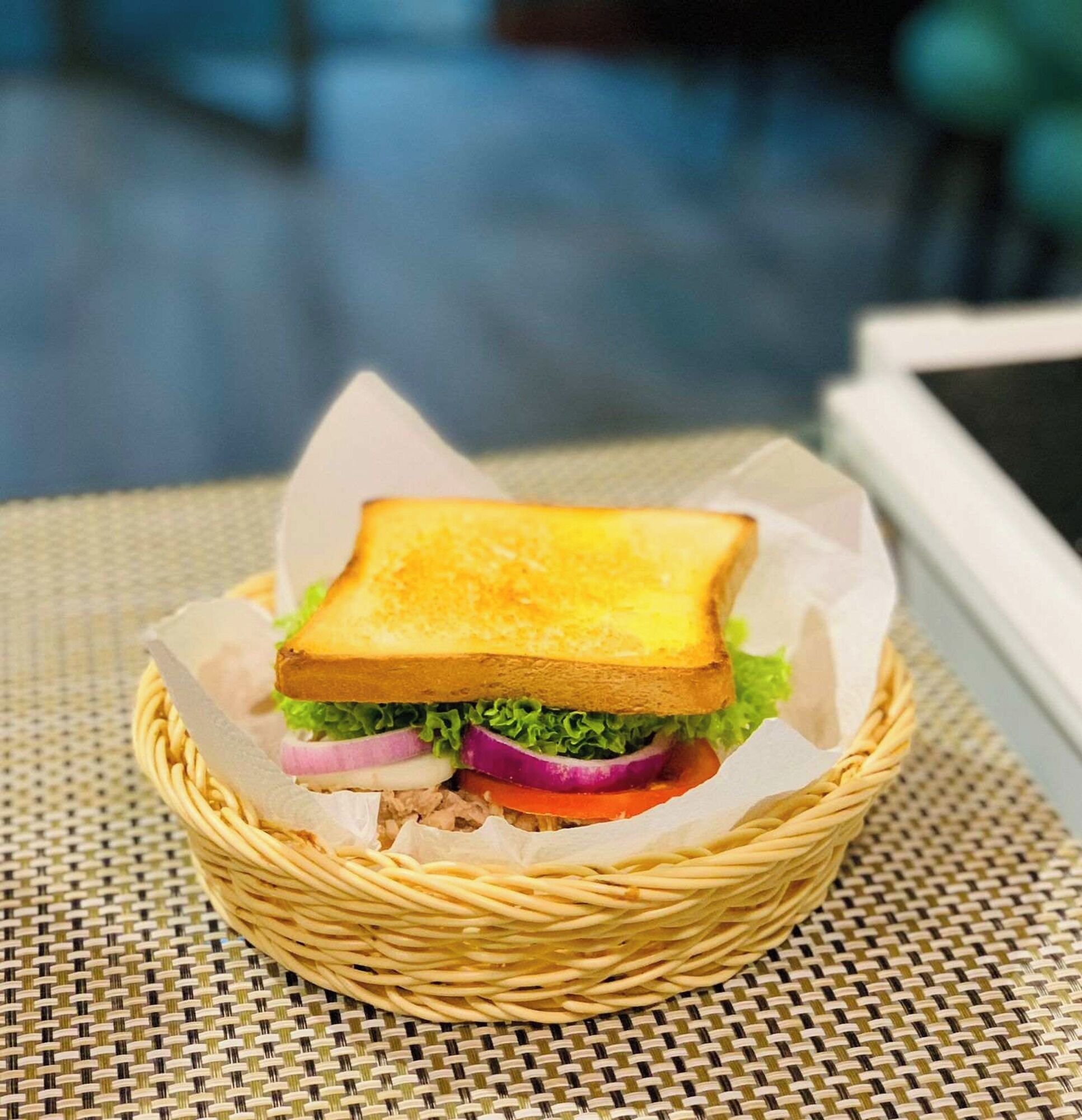 Un sándwich en una cesta de mimbre sobre una mesa.