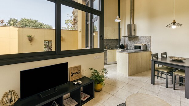 A modern kitchen with a microwave, a dining table with chairs, and a large window. - Country House 'L Heura' with Private Terrace, Wi-Fi and Air Conditioning (Navata)