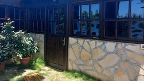 A building with a stone facade, a wooden door, and large windows. - Holiday Home 'La Carpintera' with Sea View, Private Terrace and Wi-Fi (Tijarafe)