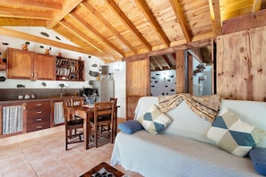 A rustic interior with wooden beams, a dining area, and a sofa with patterned cushions. - Holiday Home 'Casa Rural Medina 2' with Mountain Views and Wi-Fi - SilboHolidays (san sebastian de la gomera)