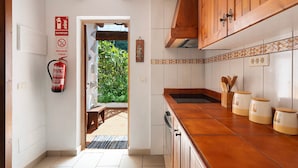A kitchen with wooden cabinets, a tiled backsplash, and a fire extinguisher.