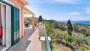 Ein Balkon mit Meerblick, eine Pergola und ein Gebäude mit einer Pfirsichfarbenen Fassade.