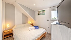 A bedroom with a bed, bedside table, lamp, and a window with a view. - Guest House 'Domaine De Pharaon' with Shared Terrace, Wi-Fi and Air Conditioning (Morlaix)