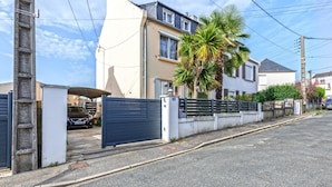 A residential street with houses, a gated driveway, and a palm tree. - Guest House 'Domaine De Pharaon' with Shared Terrace, Wi-Fi and Air Conditioning (Morlaix)