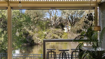 Relax on the outdoor patio with a view of the serene landscape and body of water.