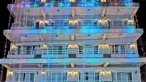 Ett hotell med flera våningar, balkonger och ljusslingor.