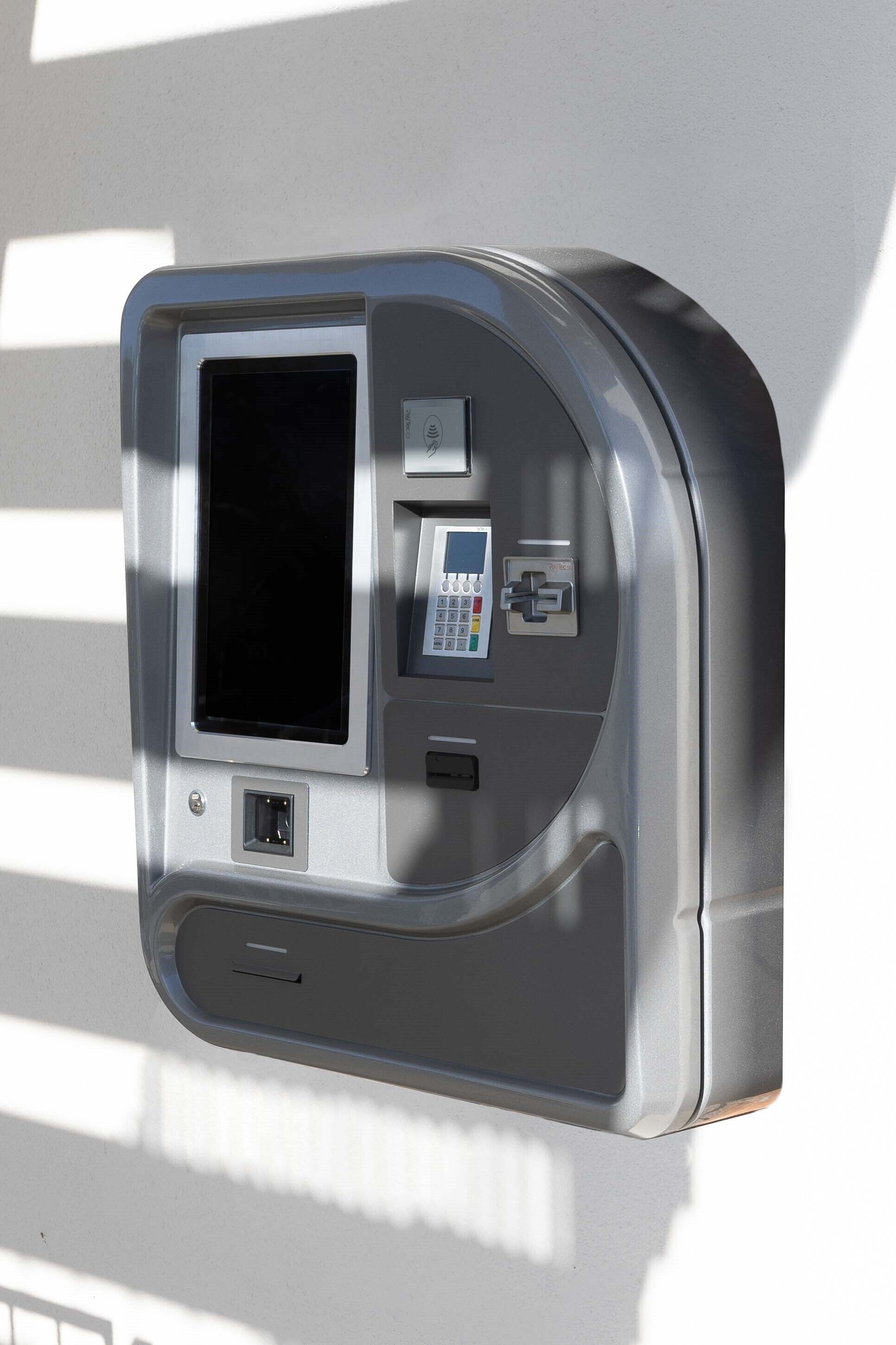 A self-service kiosk with a screen, keypad, and card slot, likely for ticketing or payments.