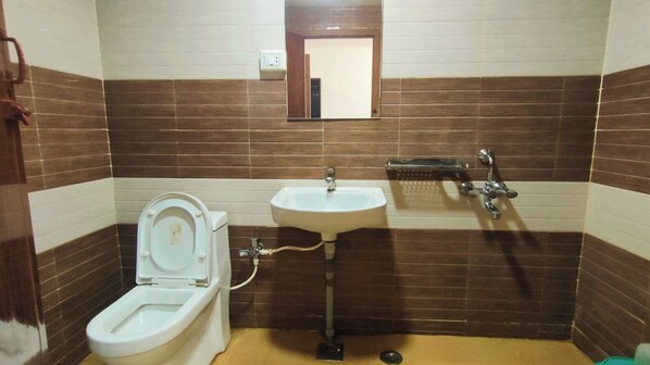 A bathroom with a toilet, sink, and shower.