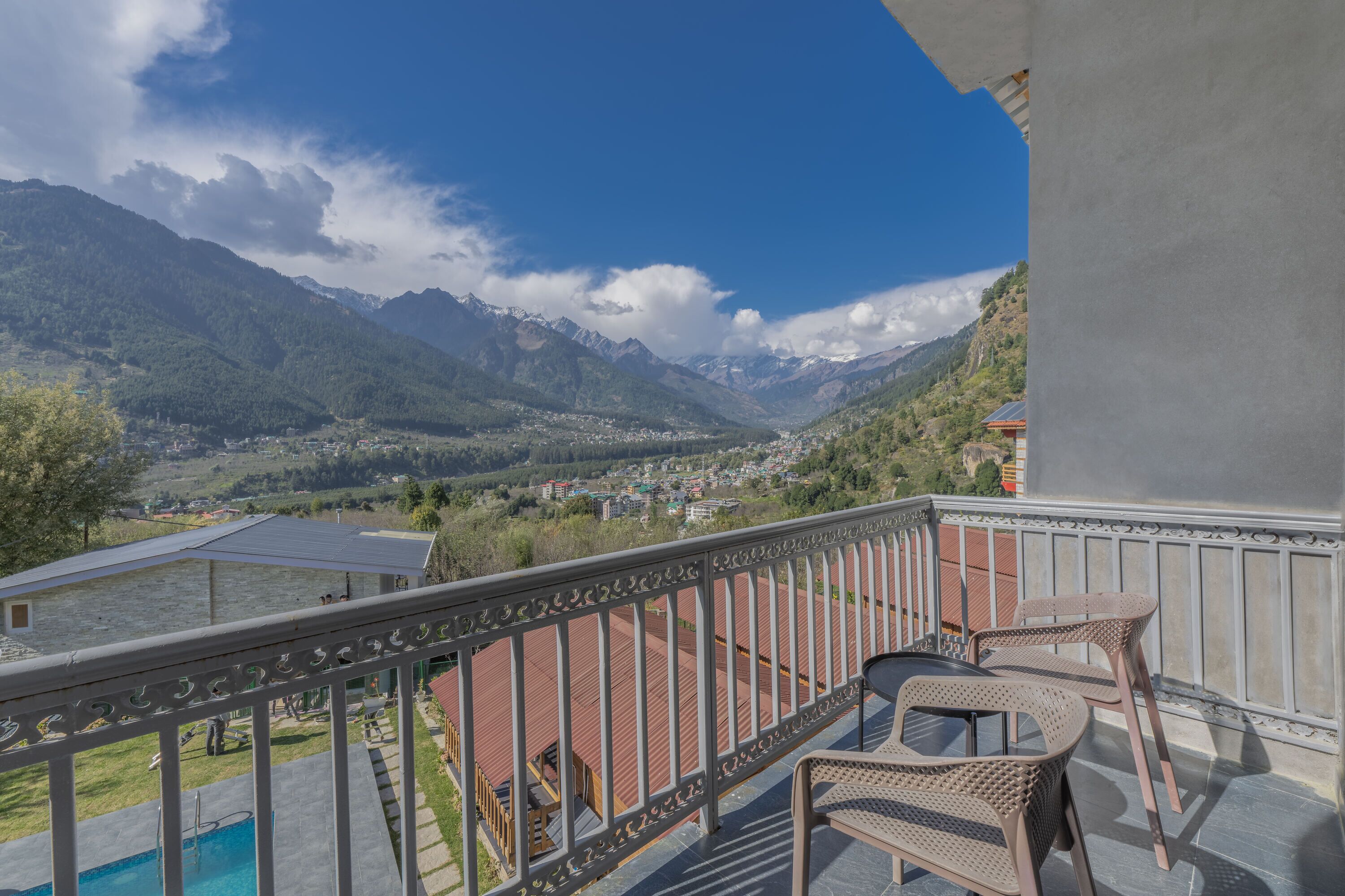 A balcony with a view of a valley and mountains.