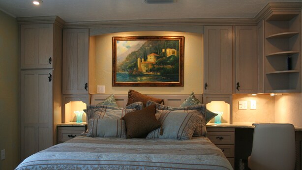 A bedroom with a large bed, a desk, and a chair. There is a painting on the wall above the bed. - The Secret In the Springs Hideaway, a luxury efficiency at the Legacy Trail (Sarasota)