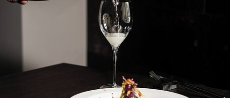 A bottle of champagne being poured into a wine glass.
