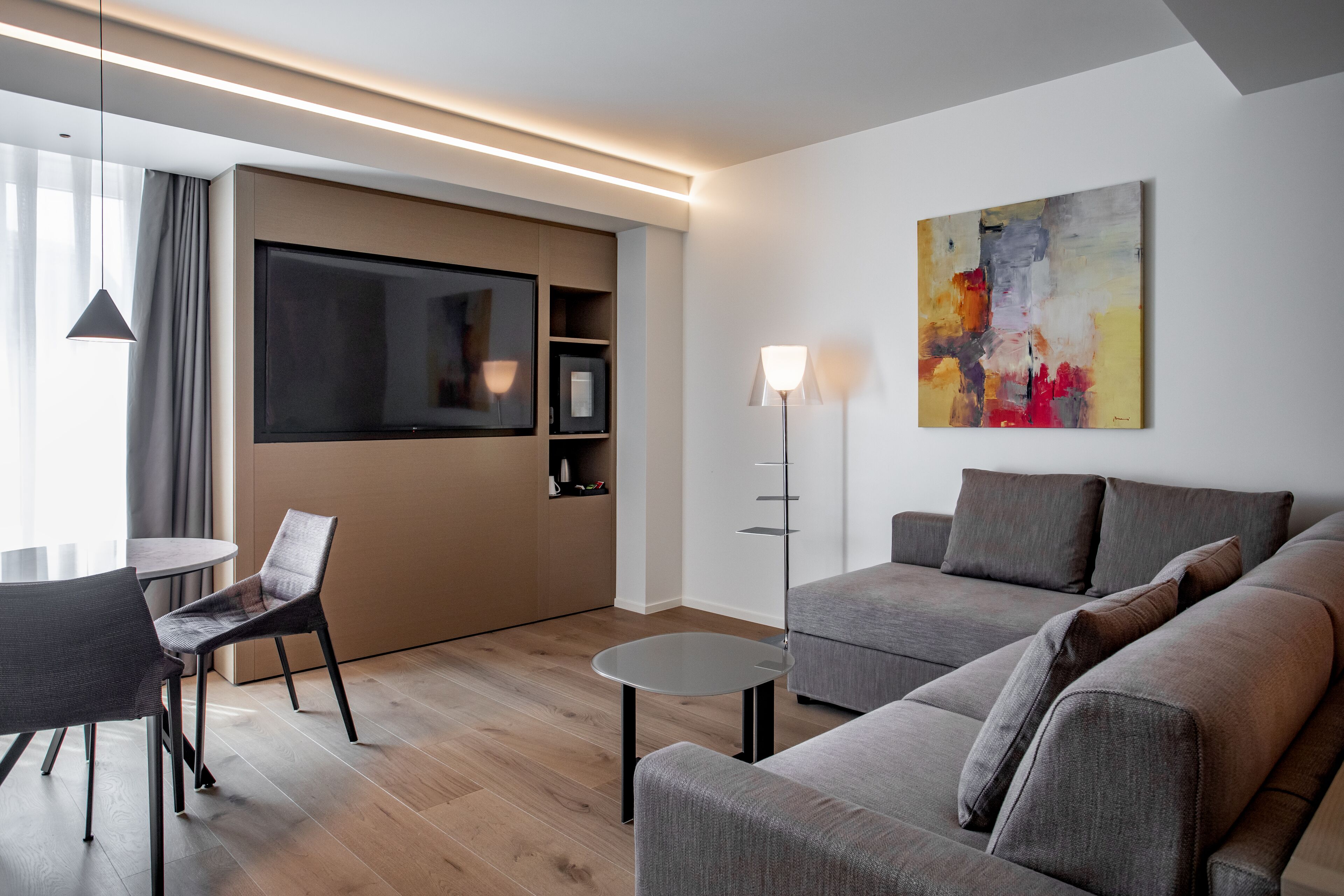 Suite Deluxe | Area soggiorno | TV a schermo piatto 65 pollici con canali satellitari