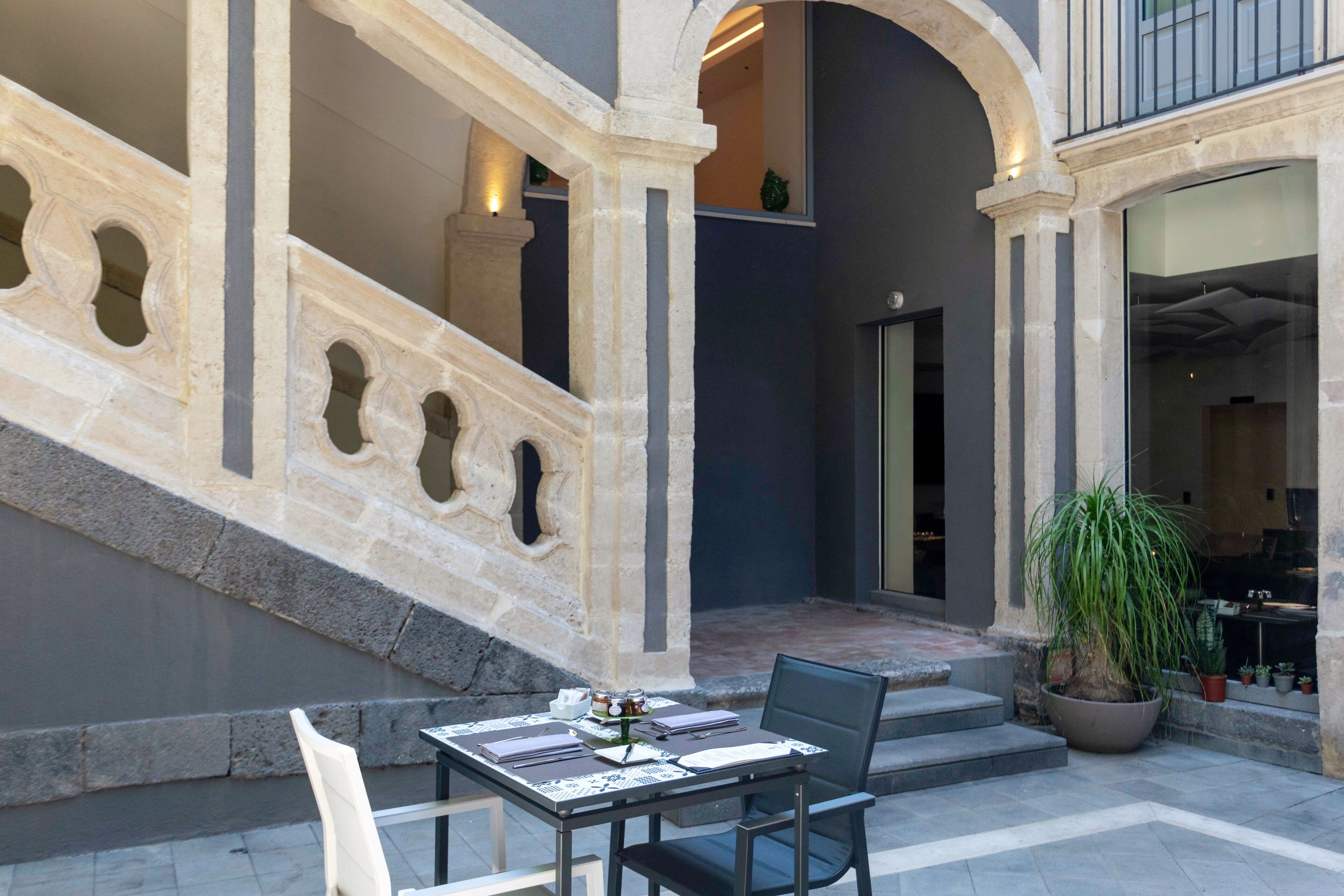 Una scala in pietra con un tavolo e sedie in un cortile.