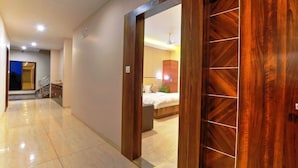 Un couloir avec une porte en bois donnant sur une chambre.