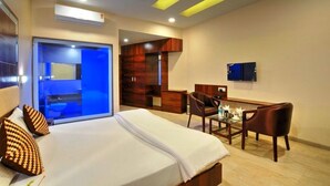 Une chambre d’hôtel avec un lit, un bureau, une chaise et un téléviseur.
