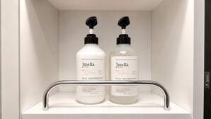 Two bottles of jmella hair treatment and shampoo on a white shelf in a bathroom. - Yeongjong Shine Hotel (Incheon)