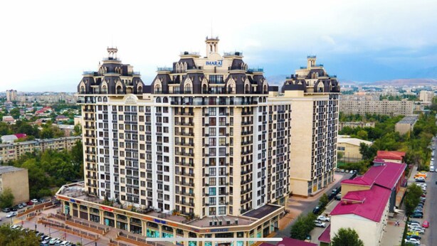 Un hotel de gran altura con un estilo arquitectónico clásico, que cuenta con varios balcones y un patio central.