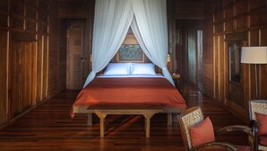Una habitación de madera con una cama, una silla y una lámpara.