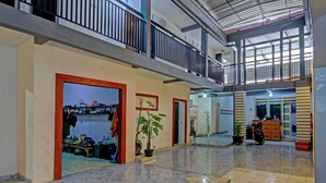 A spacious indoor area with a high ceiling, a balcony, and a potted plant. - OYO 3012 Coupis Guesthouse Syariah (Pare)