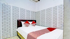 A room with a bed, white and red patterned bedspread, and red pillows. - OYO 3012 Coupis Guesthouse Syariah (Pare)