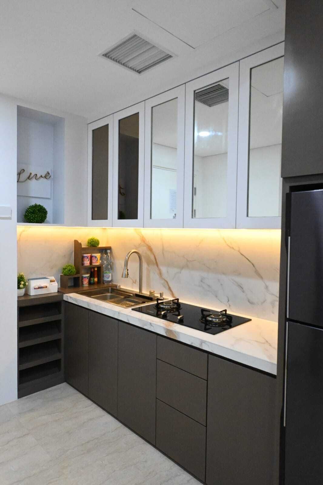 Una cocina moderna con gabinetes oscuros, encimera de mármol, pileta doble y estufa a gas integrada.