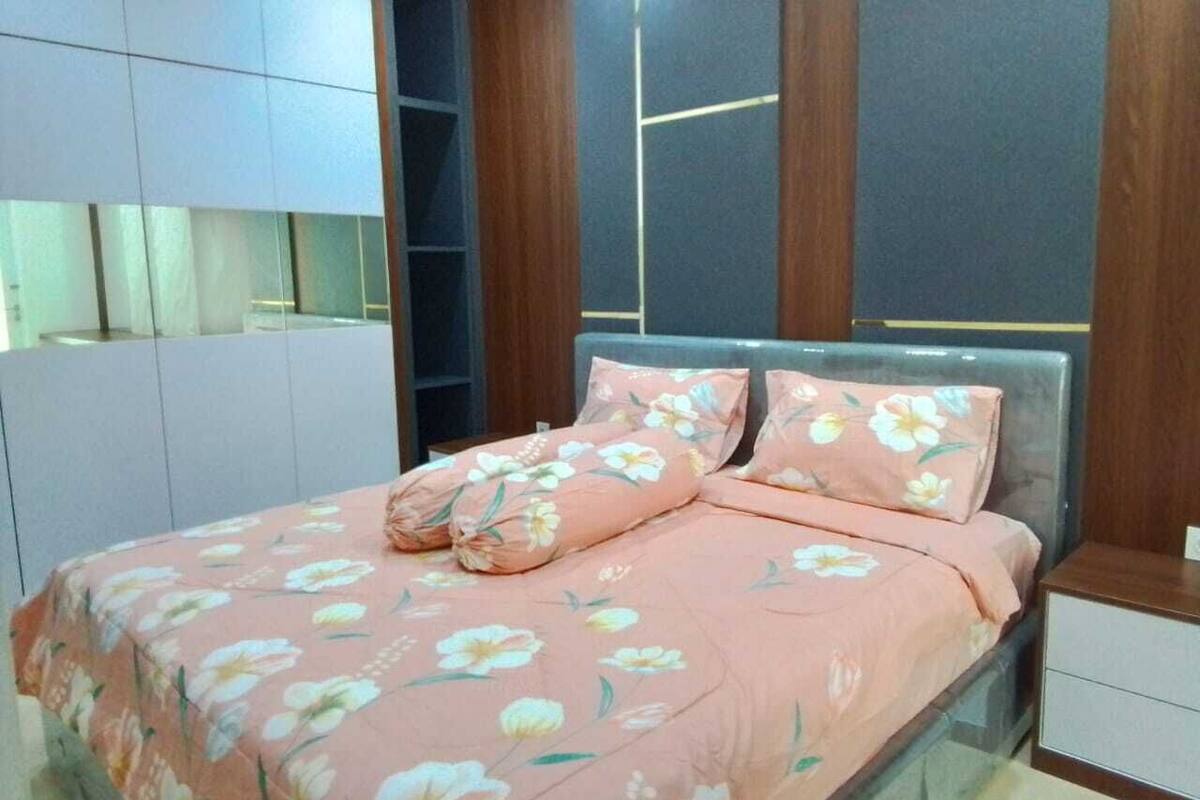Ein Schlafzimmer mit einem Bett, einem Nachttisch und Einbauschränken.
