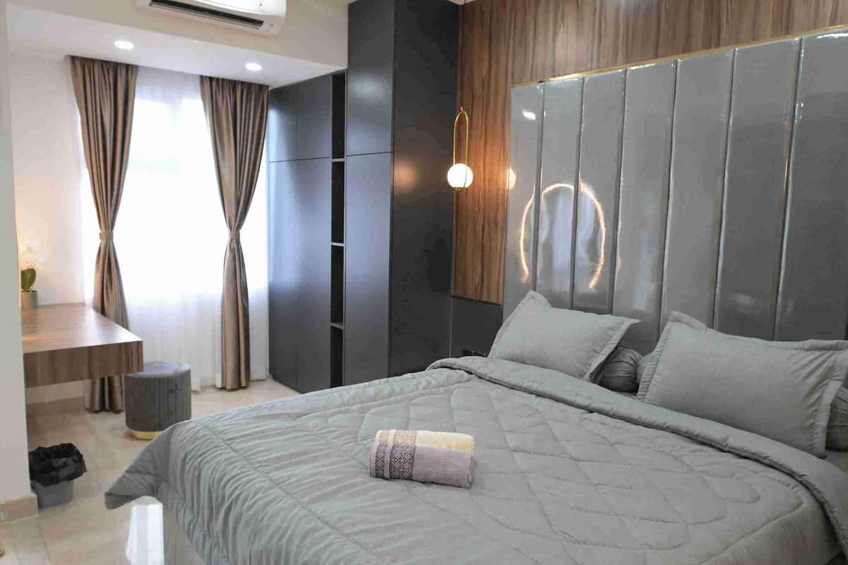 Ein modernes Schlafzimmer mit einem großen Bett, einem Schreibtisch und einem Kleiderschrank.