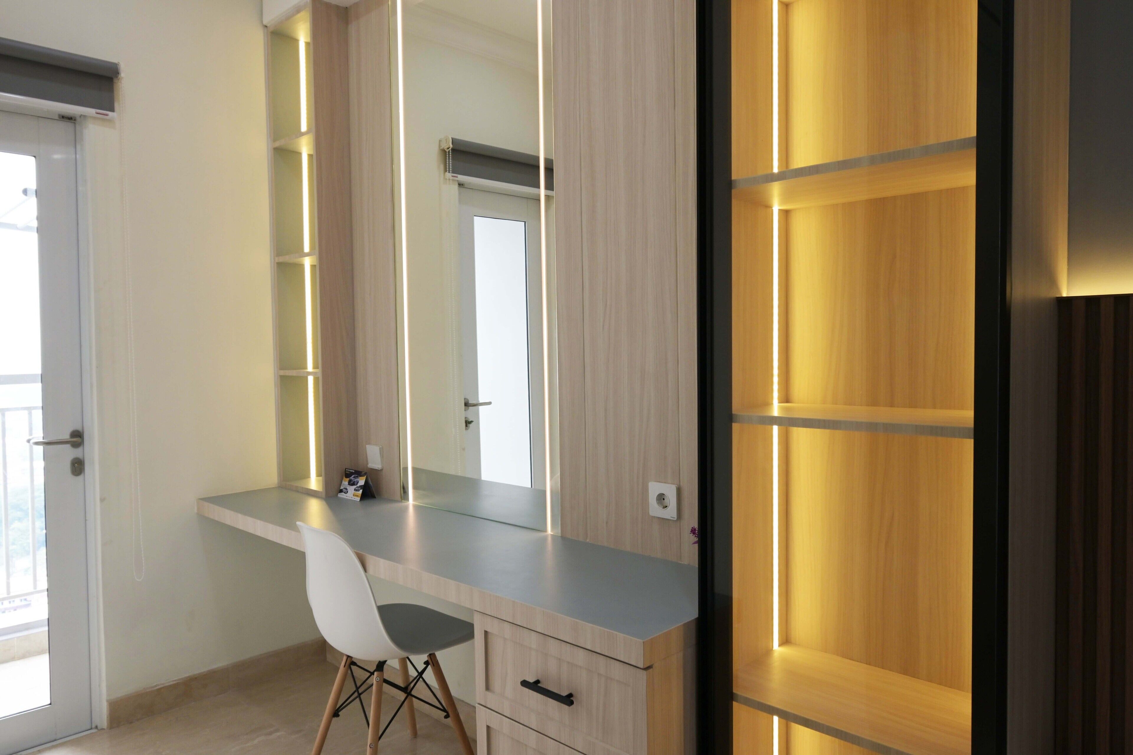 A modern bathroom with a large mirror, a vanity with a sink, and a shower area.
