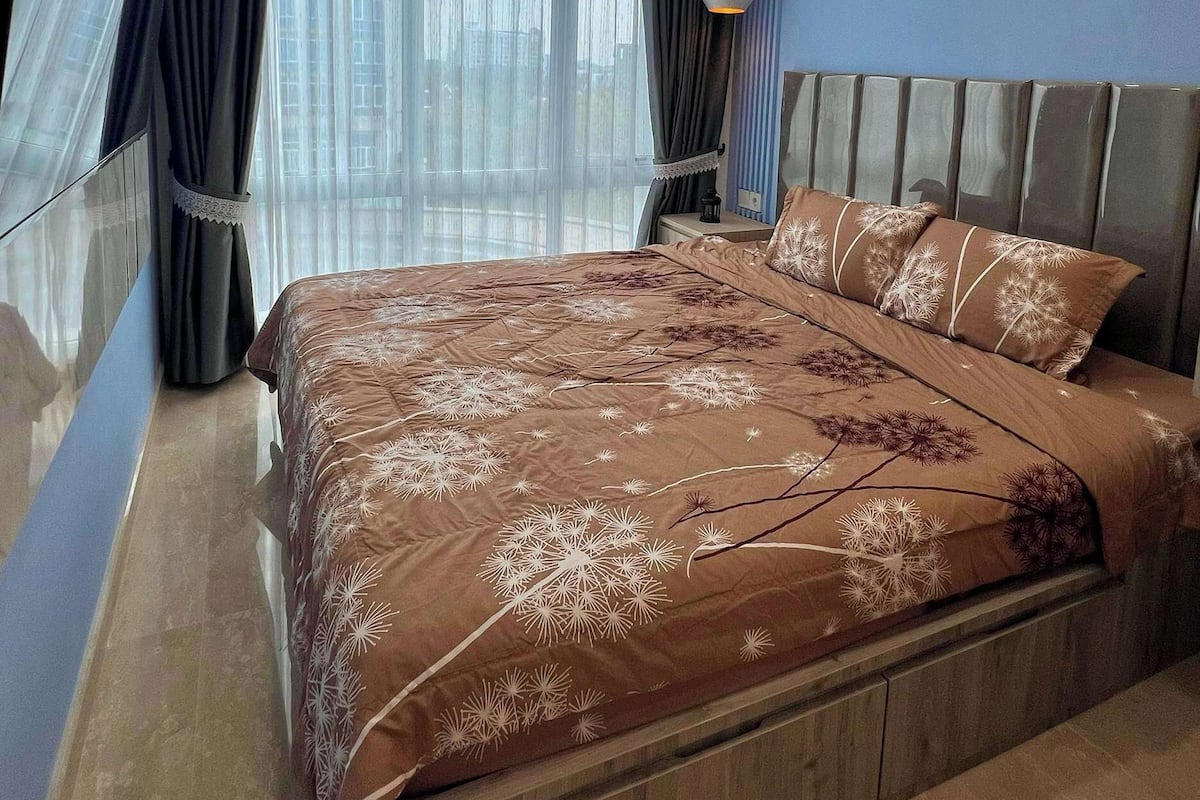 Ein Schlafzimmer mit einem großen Bett, einem Deckenventilator, einer Klimaanlage und einem Nachttisch mit Lampe.