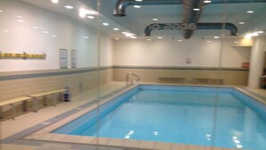An indoor swimming pool with tiled walls and a blue pool. - Olimpic Village TH Sestriere apartments x6 (Sestriere)