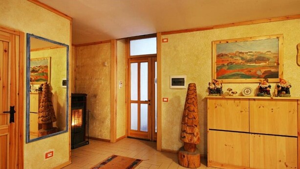 Ein gemütliches Zimmer mit Kamin, Holzschränken, einem Spiegel und einem Bild an der Wand.