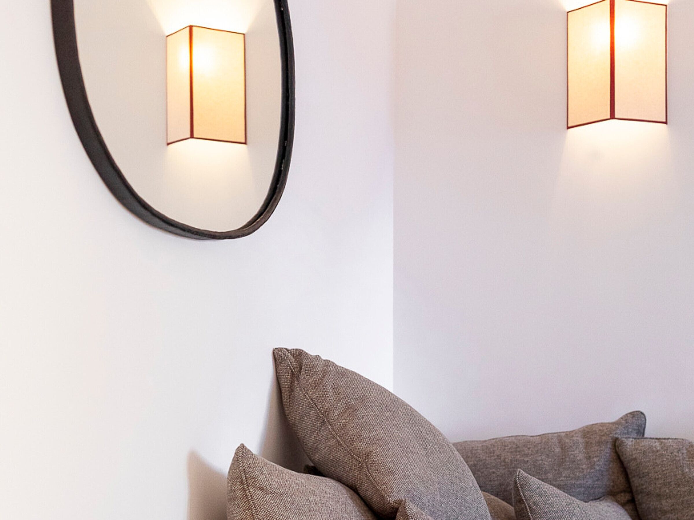 A modern room with a large mirror and two wall-mounted lights.