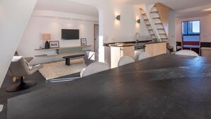 Ein stilvoller Wohnraum mit Küche, Essbereich und einer Treppe.