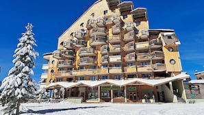 Ein mehrstöckiges Gebäude mit Balkonen in einer Skiferienregion.