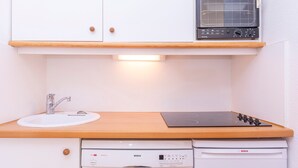 A compact kitchen with a sink, a Bosch dishwasher, a Bosch oven, and a small window above the oven. - Family apartment 6 pers. with balcony in Avoriaz (Avoriaz)