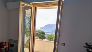 Une chambre à coucher avec un lit, une chaise et une vue sur l’extérieur.