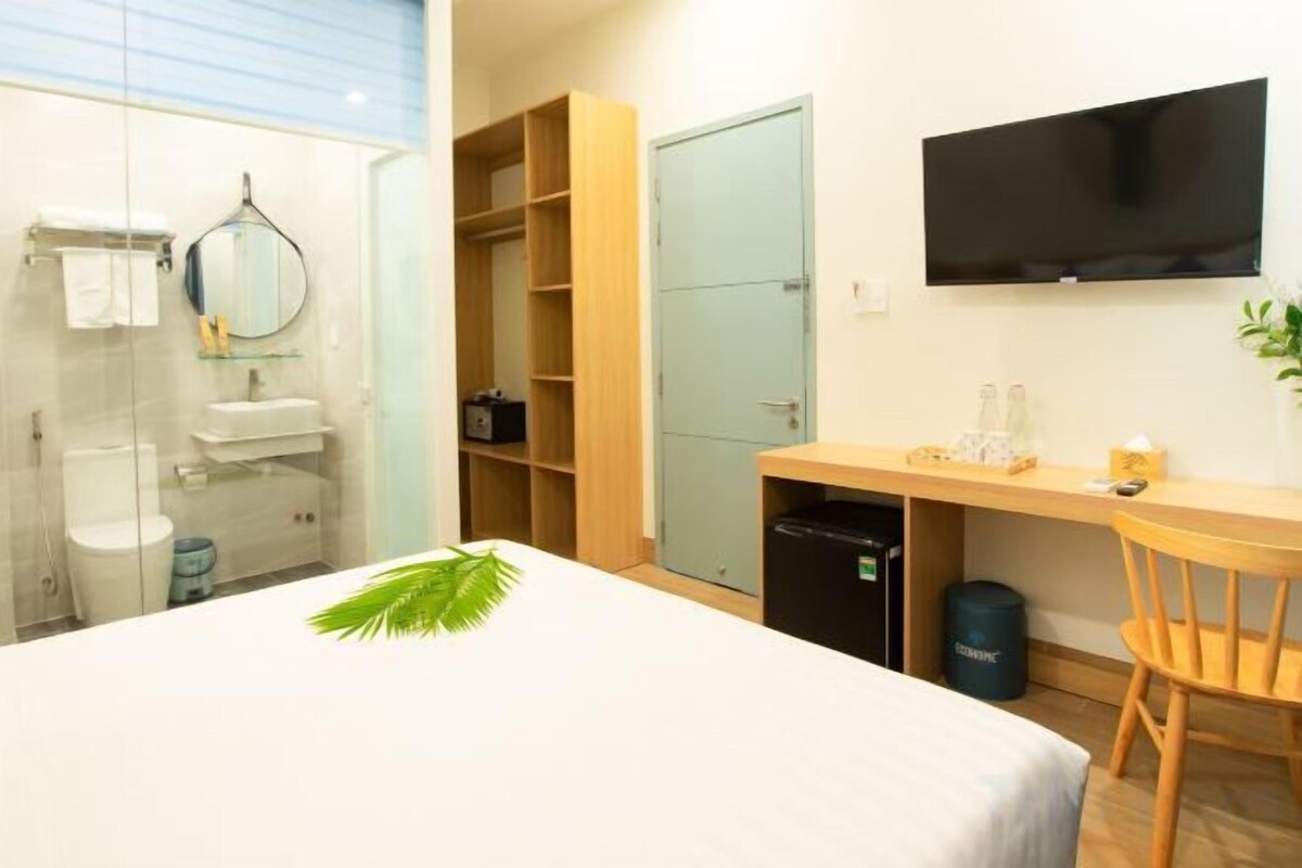 Une chambre d’hôtel comprenant un lit, un bureau, une télévision, une armoire et une salle de bain.