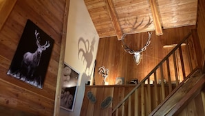 A wooden interior with a staircase, a deer antler, and a deer head mounted on the wall. - Chalet Luxueux à 500 Mètres des Pistes Avec Terrasse Plein sud (Saint-Véran)