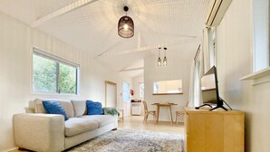 A spacious living room with a large sofa, a patterned rug, and a wooden coffee table.