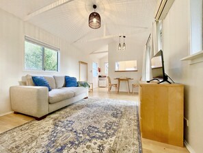A spacious living room with a large sofa, a patterned rug, and a wooden coffee table.