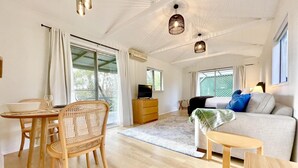 A spacious room with a dining area, a sofa, and a TV.