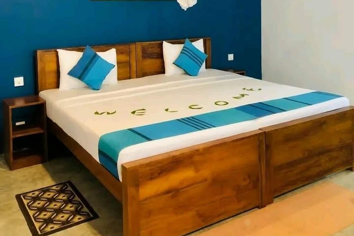 Ein Bett mit Baldachin, ein Bild an der Wand und eine Willkommensmatte.