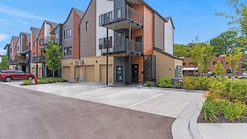 Um moderno conjunto de apartamentos com várias unidades, área de estacionamento e jardins bem cuidados.