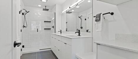 A modern bathroom with a walk-in shower, a vanity with a mirror, and a towel rack.