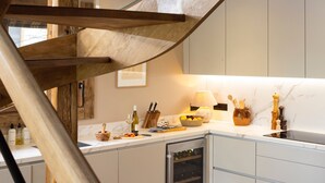 A modern kitchen with a built-in wine cooler, wooden accents, and a marble countertop. - Luxury chalet for 12 near slopes, with sauna (Saint-Martin-de-Belleville)