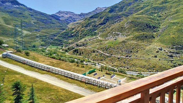 A scenic train route with a mountainous backdrop, a clear sky, and a wooden deck in the foreground. - Pleasant 2 rooms, 4 pers, south, Les Bruyères (Les Menuires)