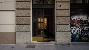 A building entrance with a metal gate, a number '9' sign, and colorful graffiti on the adjacent wall. - notaMi - Cinque Vie Top Floor City Center (Milan)